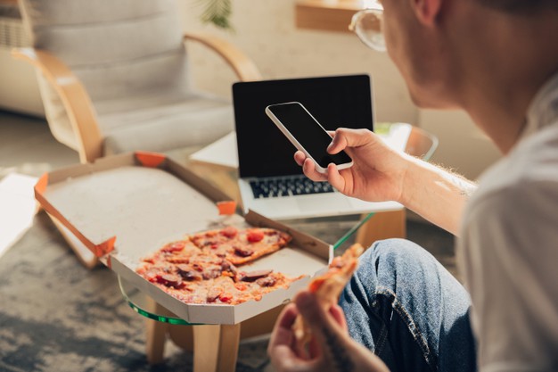 Eating pizza. man studying at home during online courses, smart school