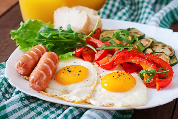 English breakfast  fried eggs, sausages, zucchini and sweet peppers
