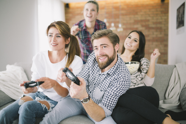 Expressive friends playing game on sofa