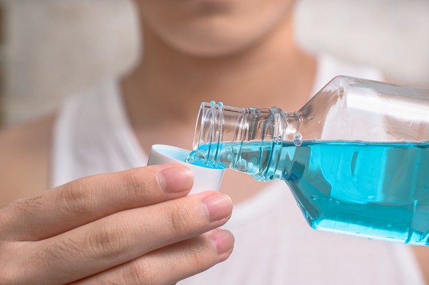 man using mouthwash