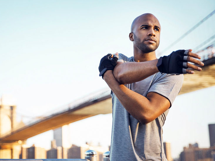 man-exercising-outdoors-arm-stretch-shoulder