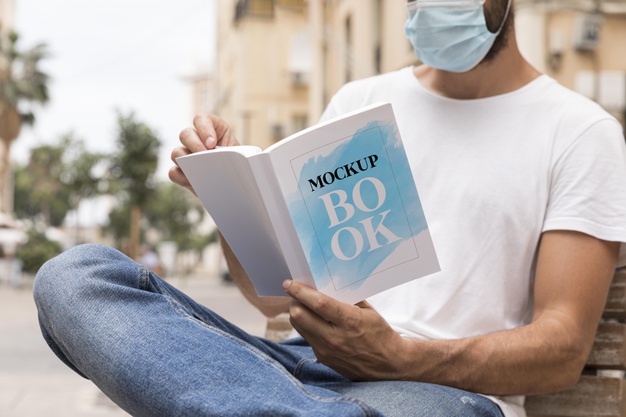 man-with-mask-street-reading-book