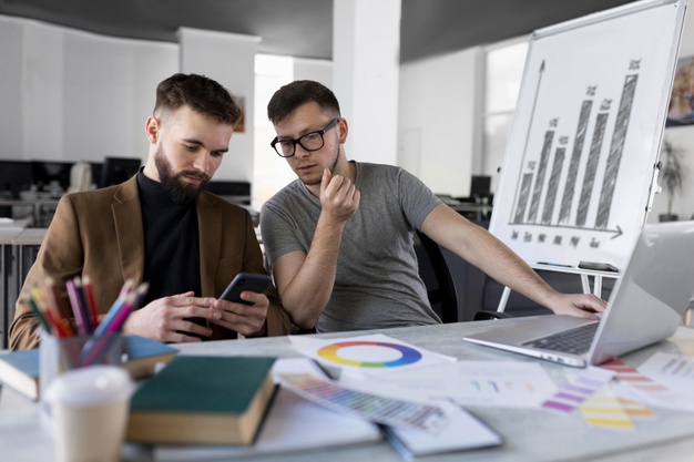 men-analyzing-graph-together-work