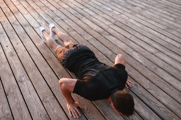 top-view-strong-sportsman-doing-push-ups