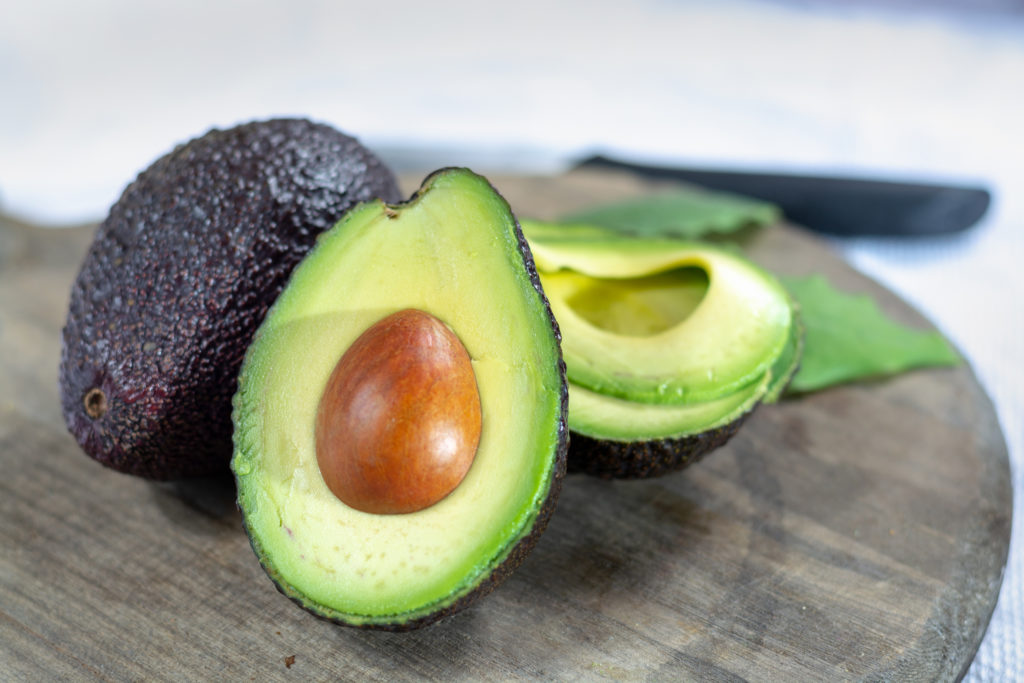 Two fresh ripe raw hass avocados