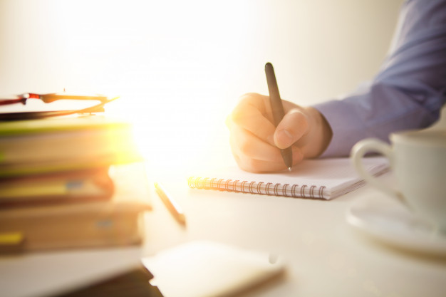 Male hand with a pen and a cup 