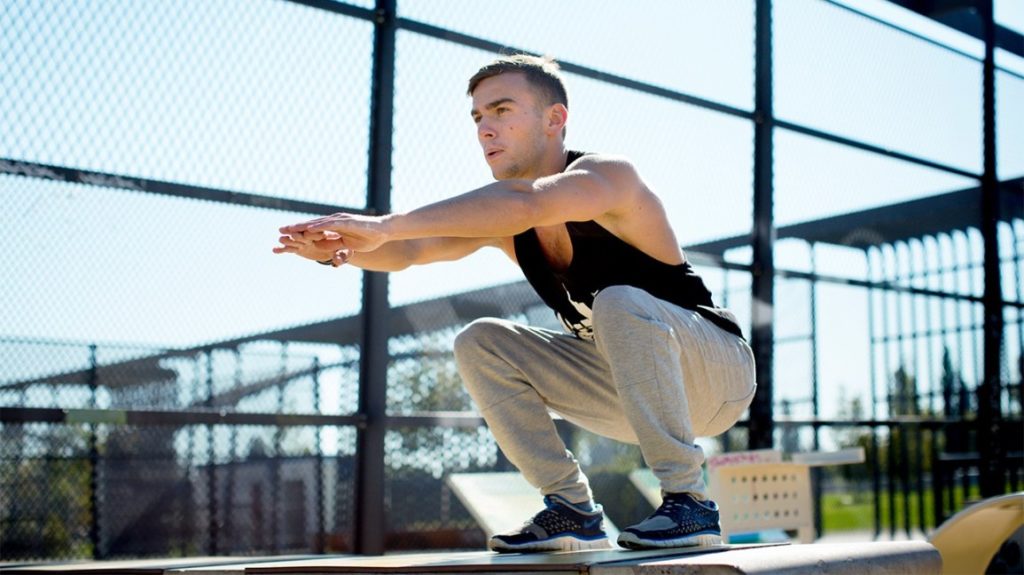 man-squatting-outdoors