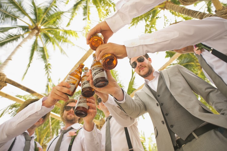 a group of men raising beer bottles