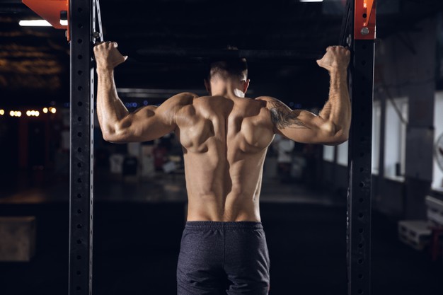 young-healthy-man-athlete-doing-exercises-pull-ups-gym