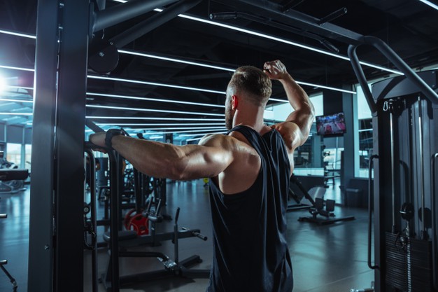 muscular caucasian athlete training in gym
