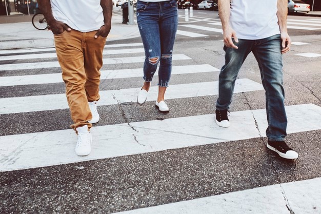 Streetwear apparel jeans men and women crossing road in city