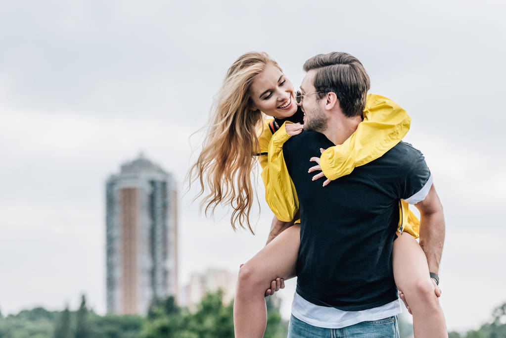 Attractive woman and handsome man smiling and playing on roof