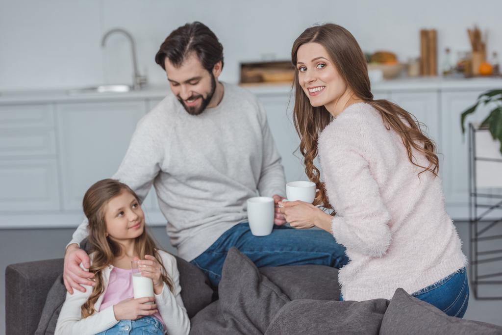 Happy parents and daughter with drinks