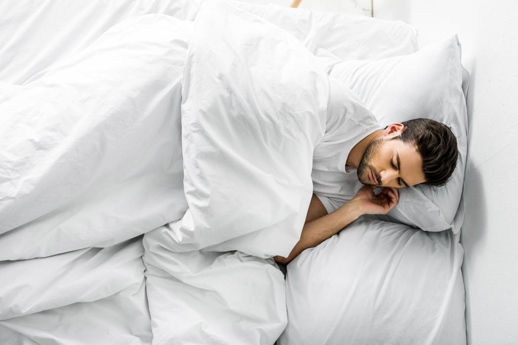 handsome young man sleeping in bed in the morning