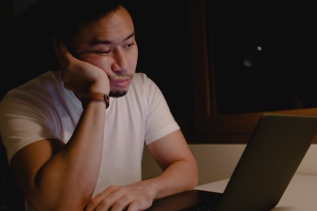 Tired asian man sleeping at office desk