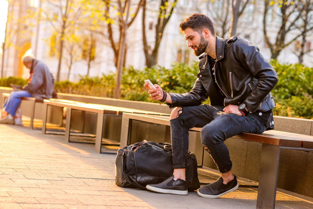 A Handsome Young Hipster Man Sitting On A Bench