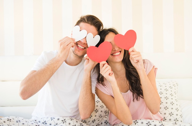Happy couple posing with paper heart