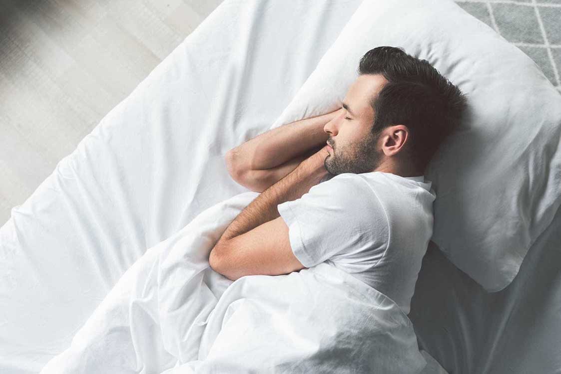 young man sleeping in bed