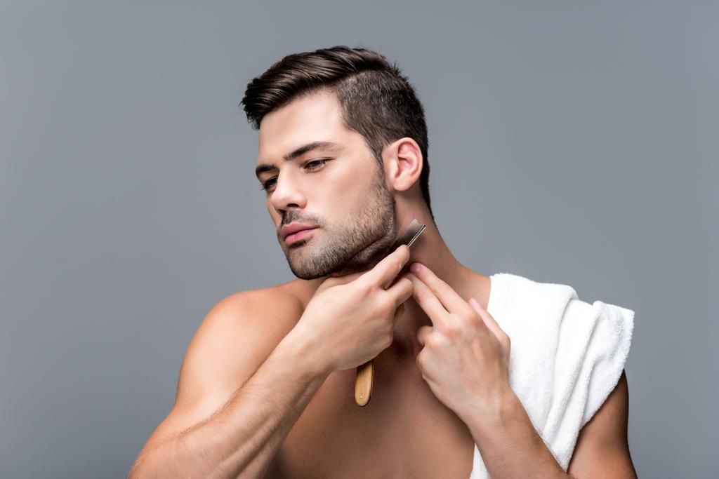 man shaving with straight razor isolated on grey