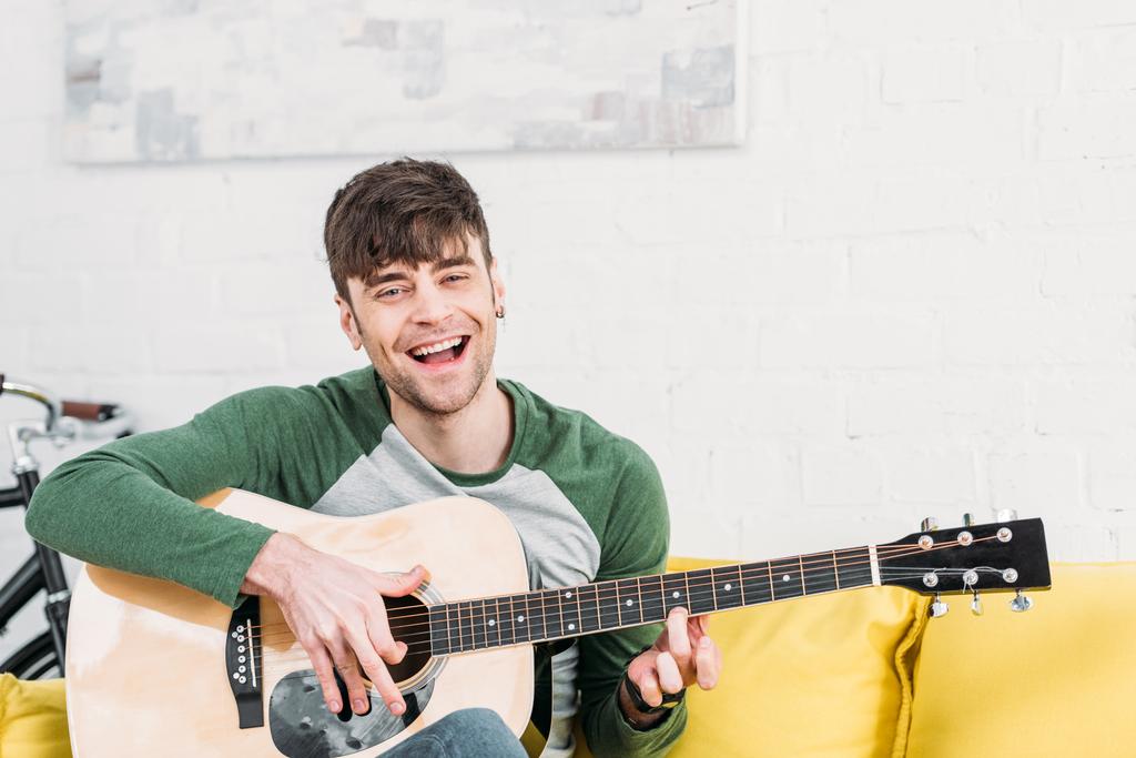 man playing acoustic guitar 