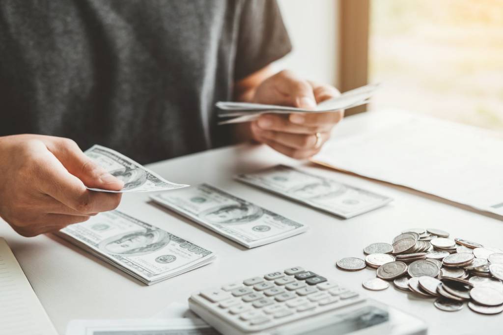 Man using calculator Accounting Calculating Cost Economic bills with money stack step growing growth saving money in home