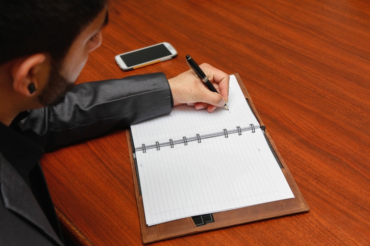 Man hand with pen writing on notebook