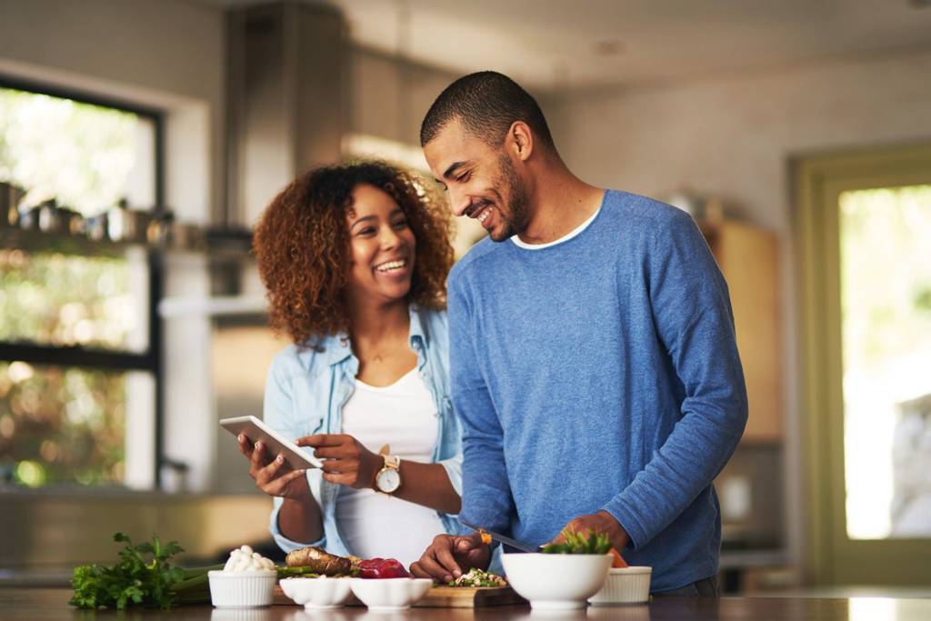 Happy Couple Cooking Food At Home Kitchen