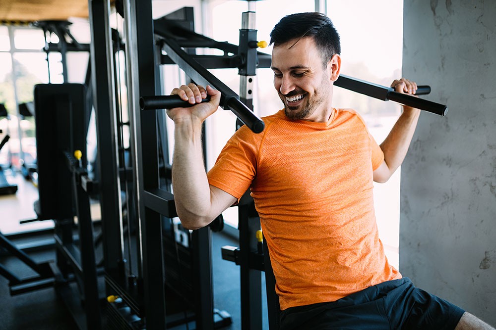 Fit man exercising at the gym on a machine  