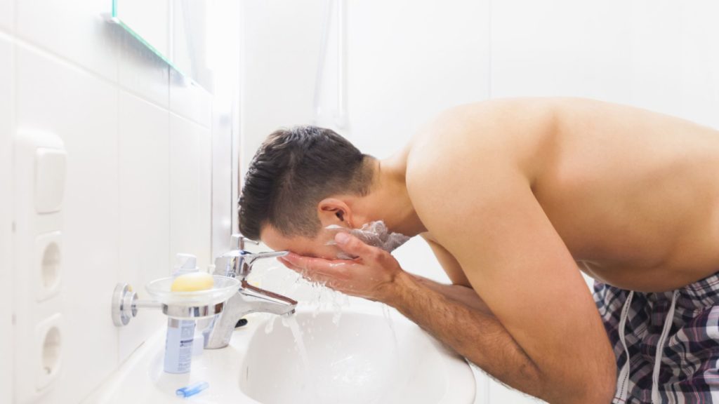 man washing face