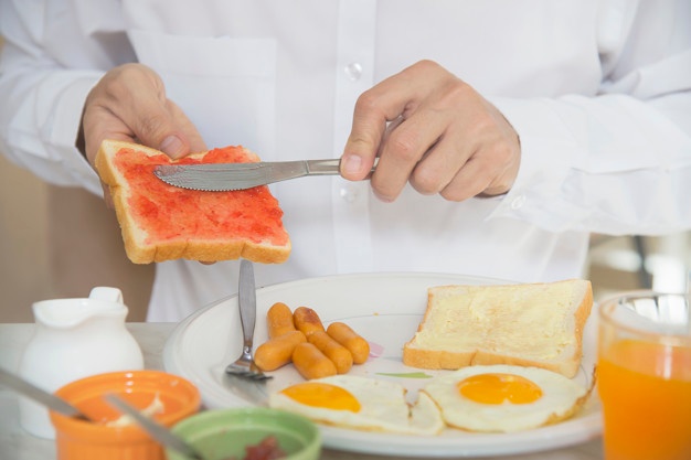 Business man eat the american breakfast set in a hotel
