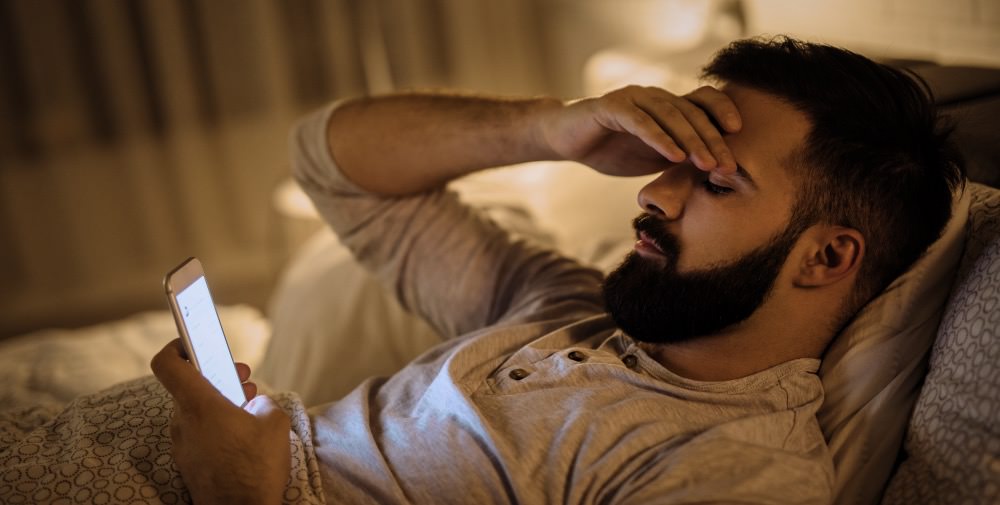 Worried young man reading bad news on smart phone