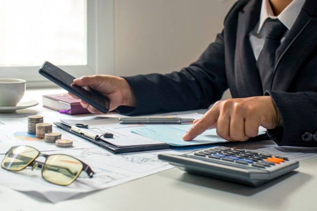 Man using calculator and calculate bills receipt in home 