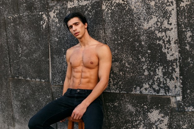 hot fit handsome young man with muscular body and bare torso showing six pack 