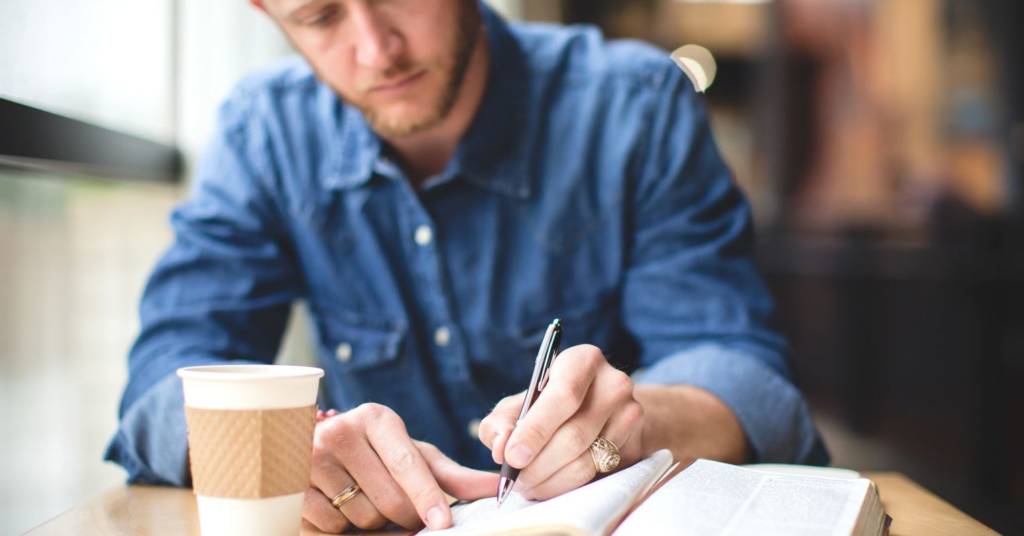 Man write down on note book 
