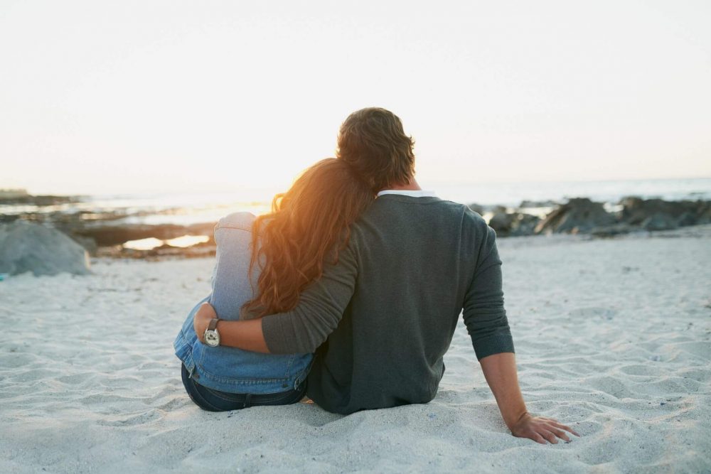Couple sitting on beach send