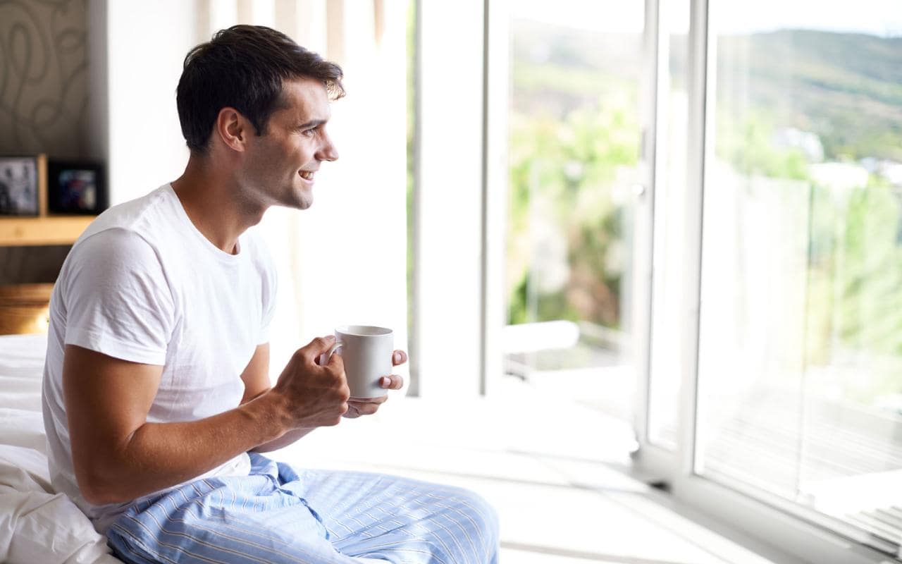 Man Waking Up Morning Sitting on Bed 