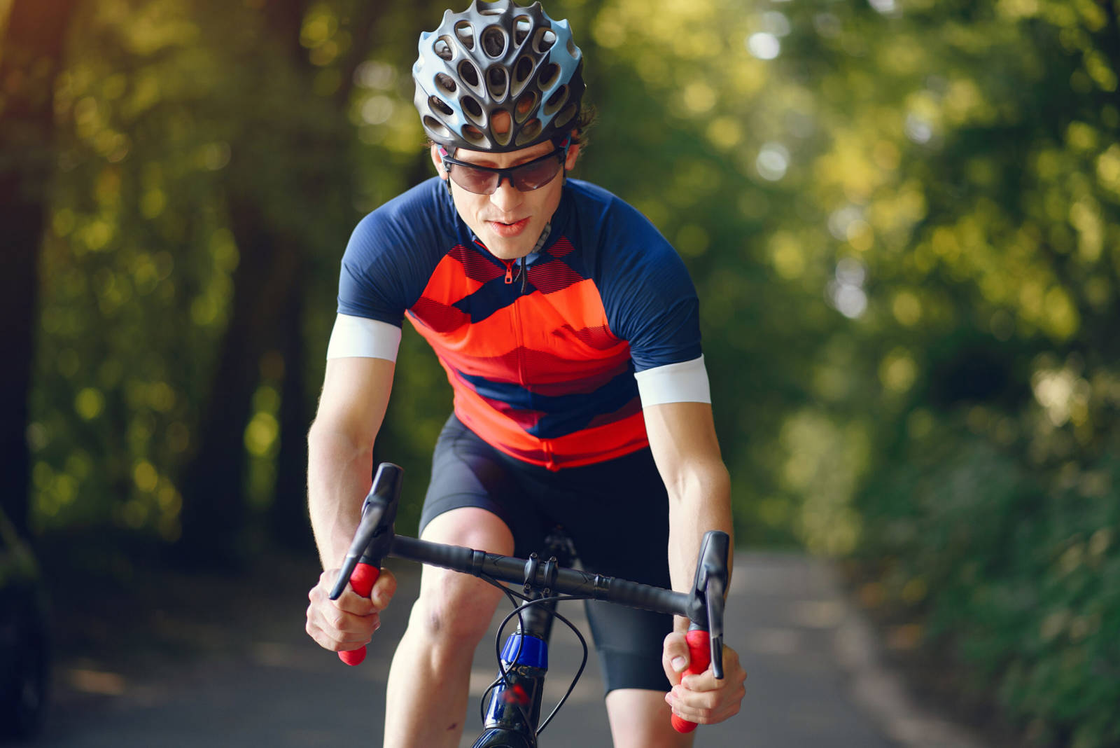 Sports man riding bike in summer fores
