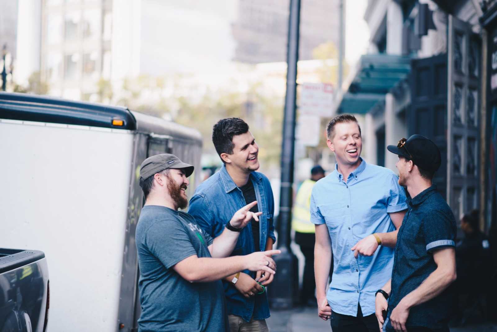 Men talking and clapping in group