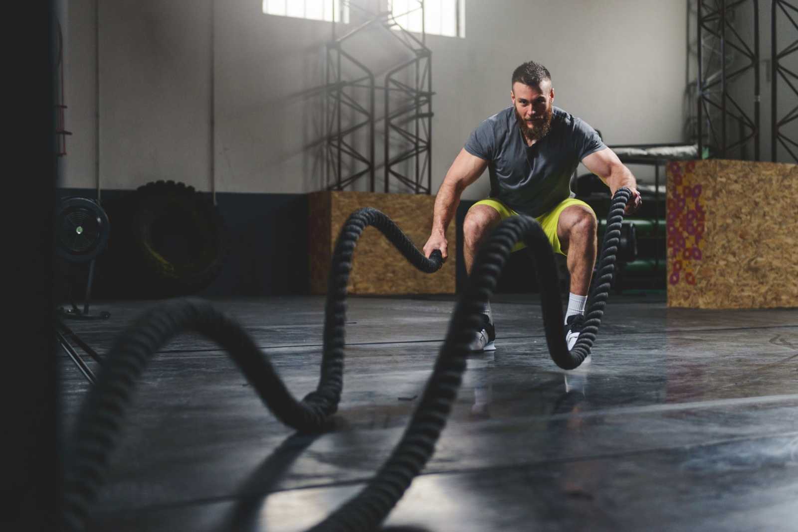 Athlete Working Out With Battle Rope At Gym 