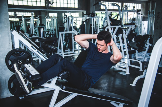 Man exercising work out and flexing muscles in gym