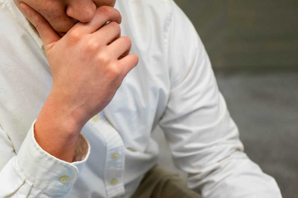  man thinking hand close up puzzled shirt businessman