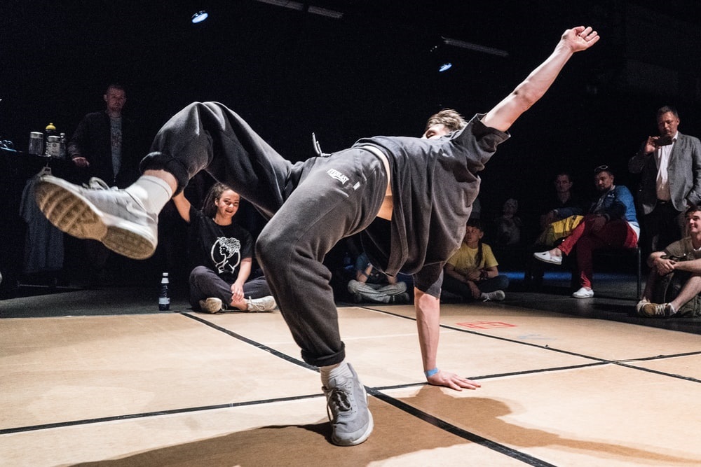  man dancing in front of people sitting on floor photo