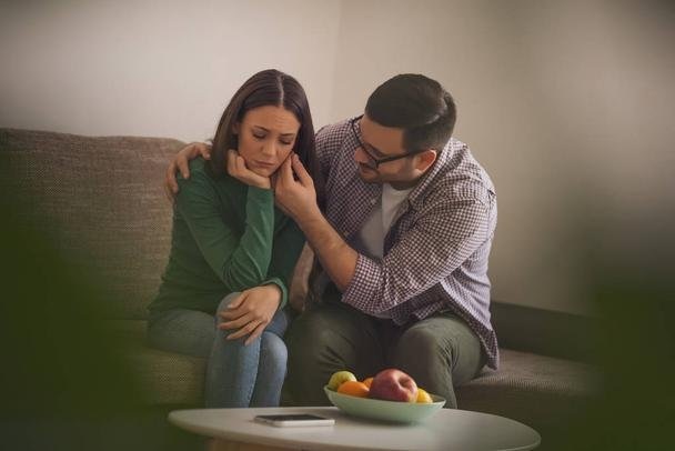 Woman is sad, her man is consoling her