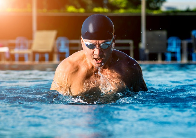 Young athletic man swimming in the swimming pool