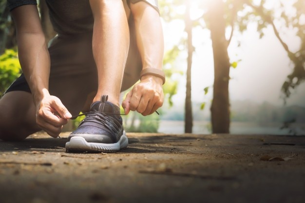 Young man runner tying shoelaces