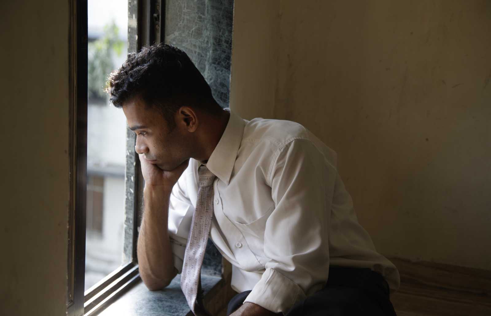 man Looking Out Window 