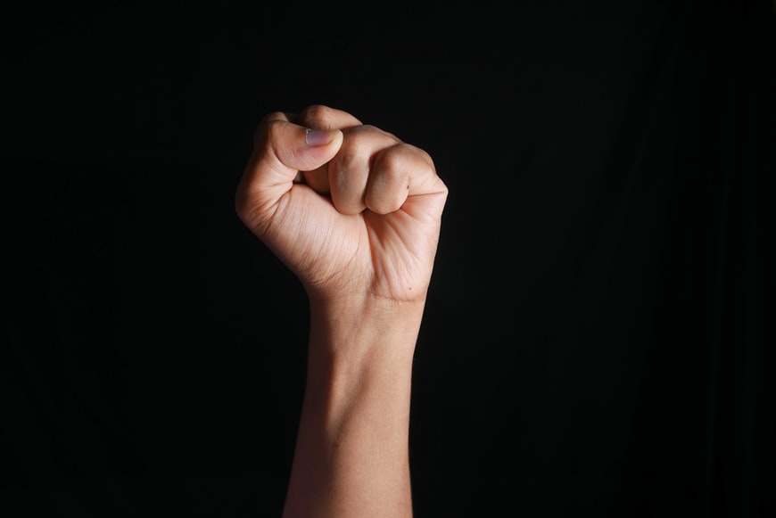 hands clenched power strength isolated on black