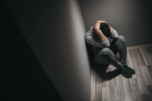 Young depressed man sitting on floor