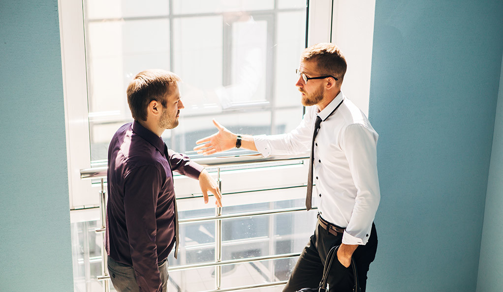 two men talking in the lobby of the modern office