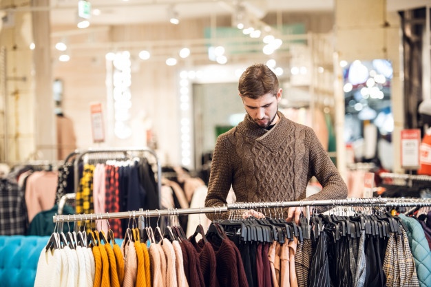 A handsome young man shopping at a clothing store
